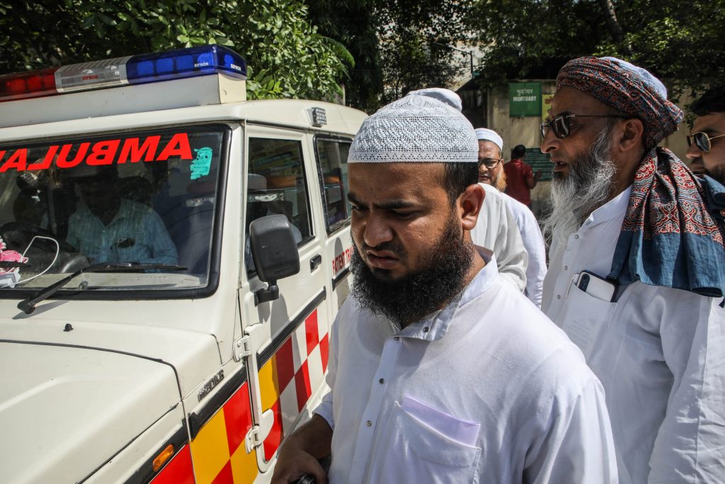 Mohammad  Shadab, 30, brother of slain Imam Maulana Saad waits for his dead body near a police van. Photo: Meer Faisal.
